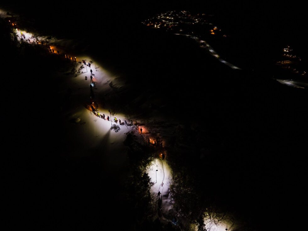 Dronebildet viser fakkeltoget som beveger seg oppover den lyssatte stien. (Foto: Jens Martin Olsen)