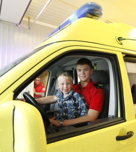Espen var storfornøyd med å få prøvesitte ambulansen sammen med lærling Simen Mortensen. Alle ungene fikk også en kjøretur - selvsagt forsvarlig sikret.