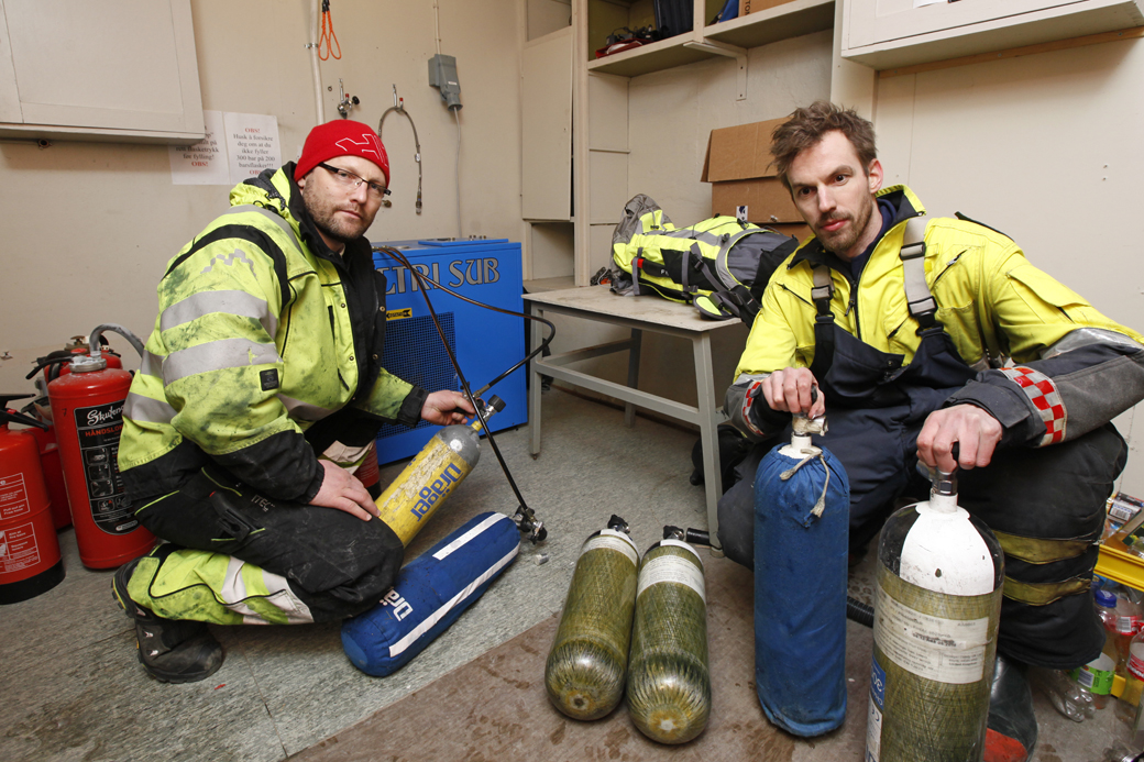 BRANN-DUGNAD: Raivis Baltris i AQS stilte opp på dugnad for å hjelpe brannmannskapene å fylle luft. Det gikk med store mengder oksygen da brannen blusset opp igjen lørdagskvelden og Hasvåg på nytt var i fare. Mikael Løfsnæs Haagensen kjørte flaskene utover.