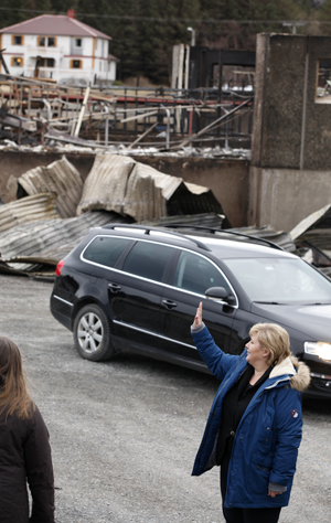 Erna Solberg vinker adjø til Harald og Turid Jacobsen, etter å ha sett brannruinene på Hasvåg vestre.