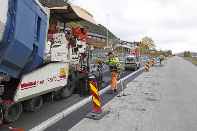 Asfalt ble lagt tirsdag, og i bakgrunn ser vi steinsetting av skråninga mot et av bolighusene i Fløanskogen.