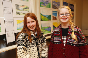 Ida Strand Kjendlie og Maria Trefjord Derås foran sine bilder på utstillingen.