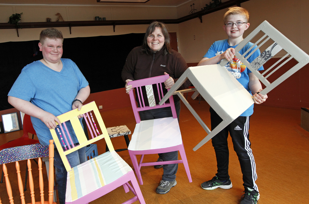 Elever fra Utvorda har redesignet stoler, og Tommy Hasvåg, Kari Imsgard og Simon Stamnes Hågensen prøver å plassere dem i utstillinga.