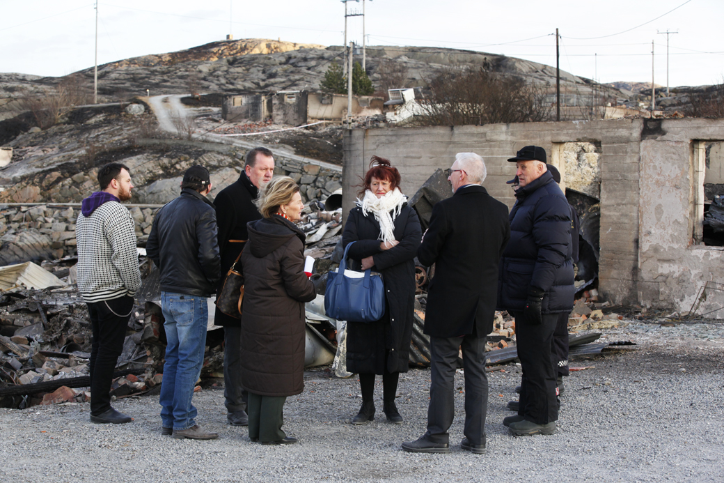 SMÅVÆRET: Lillian Mårvik Engbakken og Nils Engbakken fortalte kongeparet om turistanlegget de drev, og om Småværet. De hadde med bilder slik at Kongen og Dronningen skulle få et inntrykk av hvordan det så ut før brannen. - Her skal det skinne, sa dronning Sonja som ville komme tilbake for å se Småværet etter gjenoppbygginga.