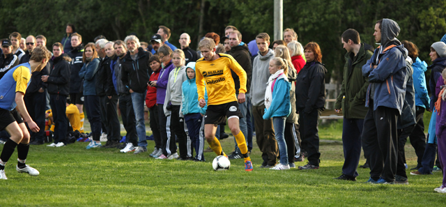 Flatanger-spillerne hadde publikum i ryggen, her Ola Kristian Dahle Høstland som dribler seg framover på banen.