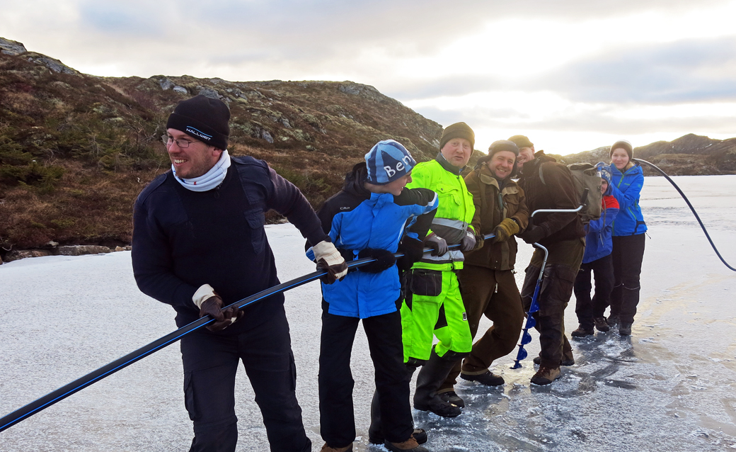 SIKRET VANN: For å sikre vanntilførselen til Utvorda, stilte folk opp på dungad for å dra en 600 meter lang slange opp til Innvordvatnet. Fra venstre: Sven Gust, Julian Sandhøfer, Hans Flore, Nils Myren, Alf Åge Teigmo, Ole Marius Søberg Angell og Hanne Myren. (Foto: Øivind Strøm)