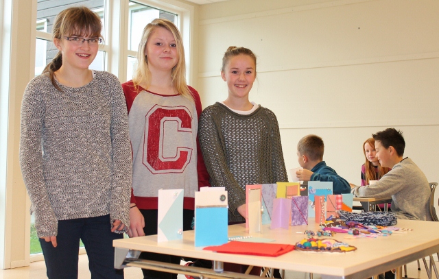 Amalie, Tina og Matilde viser fram kort og andre fine produkter.