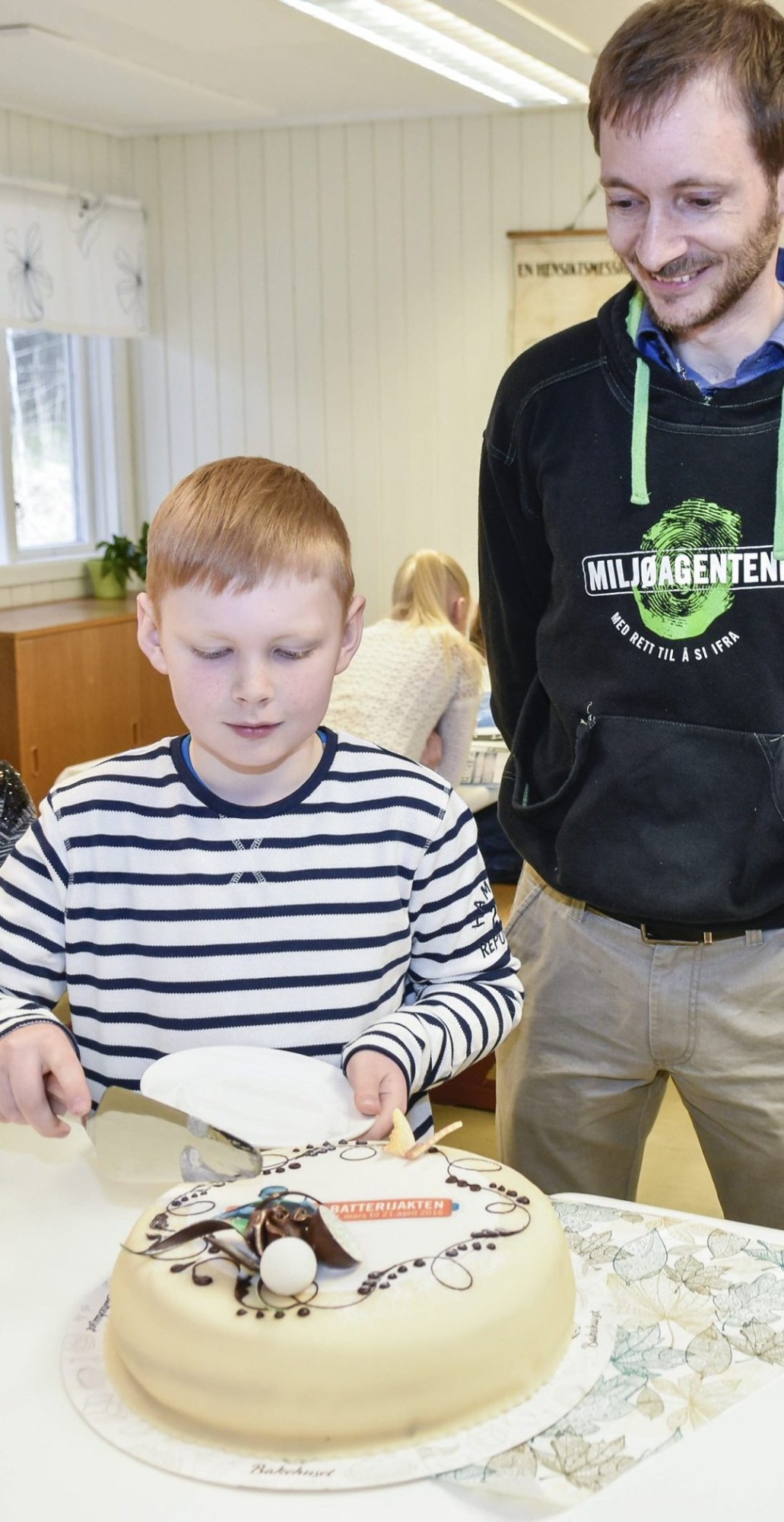 Magnus Tyldum Ribsskog fikk skjære det første stykket av kaka sammen med sjefagent Are Shaw Waage. (Foto: Øivind Rånes, Namdalsavisa)