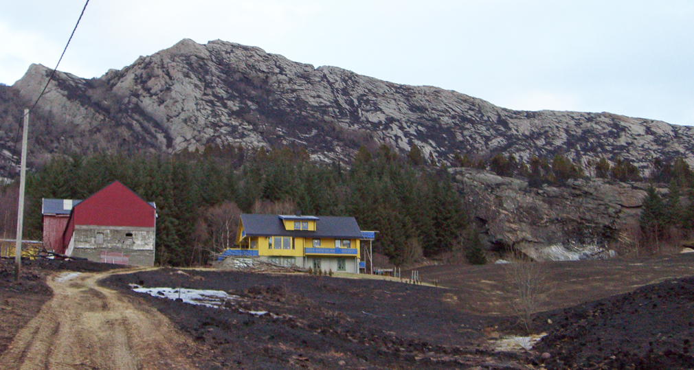 Som et symbol på tross, sto gårdsbygningene på Hårstad etter brannen. Det var svart rundt på alle kanter, men husene berget. Kanskje gjorde granskogen bak at flammene feide over, kanskje var det den kortklipte plena som berget husene. (Foto: Agnes Hårstad)