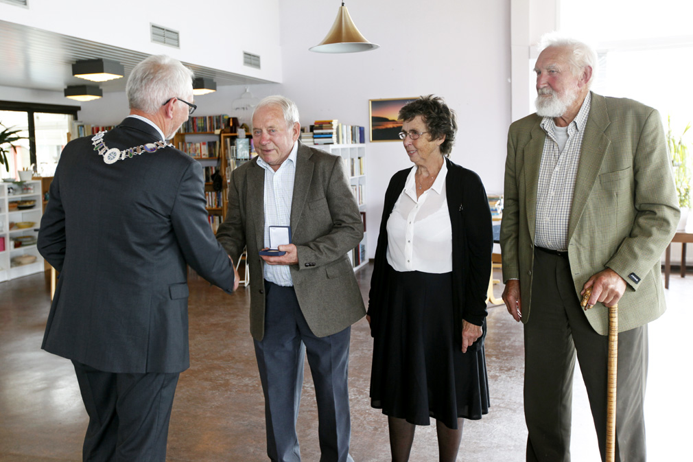 Peder Kristiansen mottar medaljen, mens Ragnhild Strøm og Peder Skjengen venter på tur. Medaljene ble delt ut av ordfører Olav Jørgen Bjørkås.