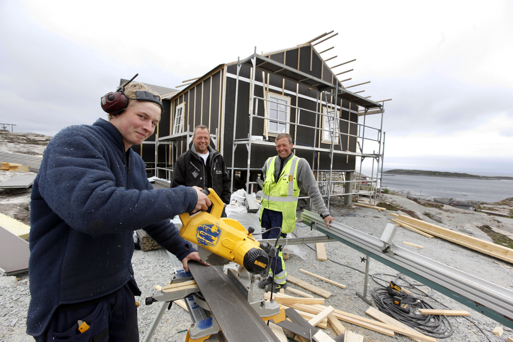 Lærling Johannes Ramberg og tømrer Martin Tyldum i Spar-Bygg har ført opp det første råbygget i Grønnvika hytteområde, som Frode Opheim har opparbeidet.