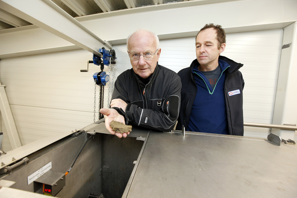 Arne Hjalmar Knap viser fram tørrstoffet som er hentet ut fra avløpsvannet. Morten Strøm satser på selge det som gjødsel.