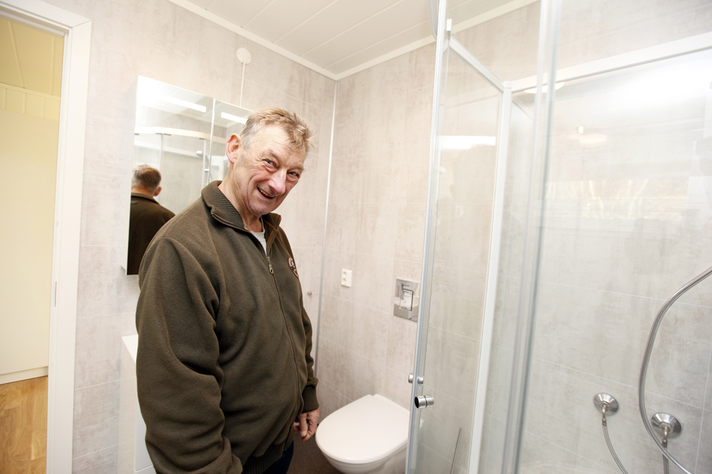 Terje sjekker det nye badet, med dusjkabinett og egen avdeling for vaskemaskin.