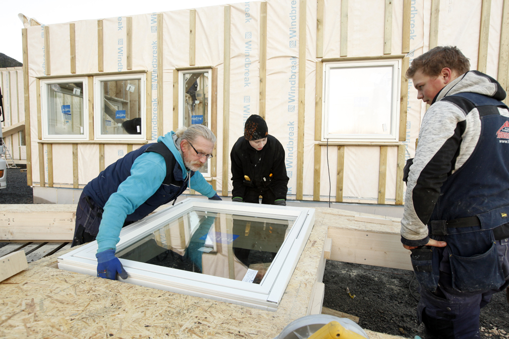 Oddvar Ledang, Mikael Strand og Karl Oskar Andersen monterer vindu i en av veggene til kontorfløya.