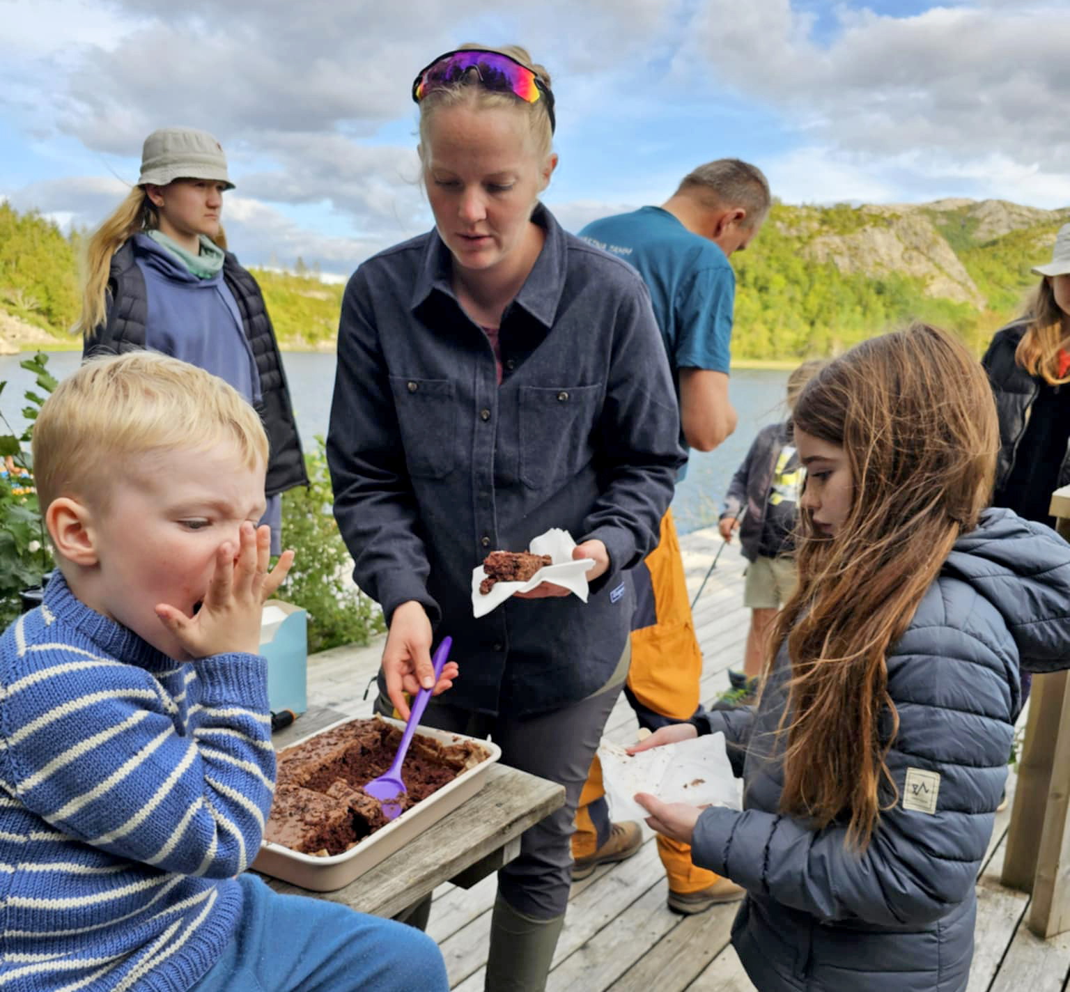 Og etter maten er det tid for kake. Ingrid Marie Myren skj&aelig;rer opp, og Elias og Meri-Lea forsyner seg. (Foto: Mari-Liis Olsen)