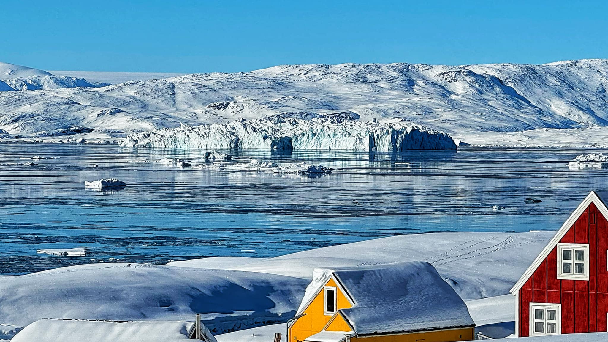 Rett som det er flyter et isfjell forbi innbyggerne på Tinit. Foto: Privat.