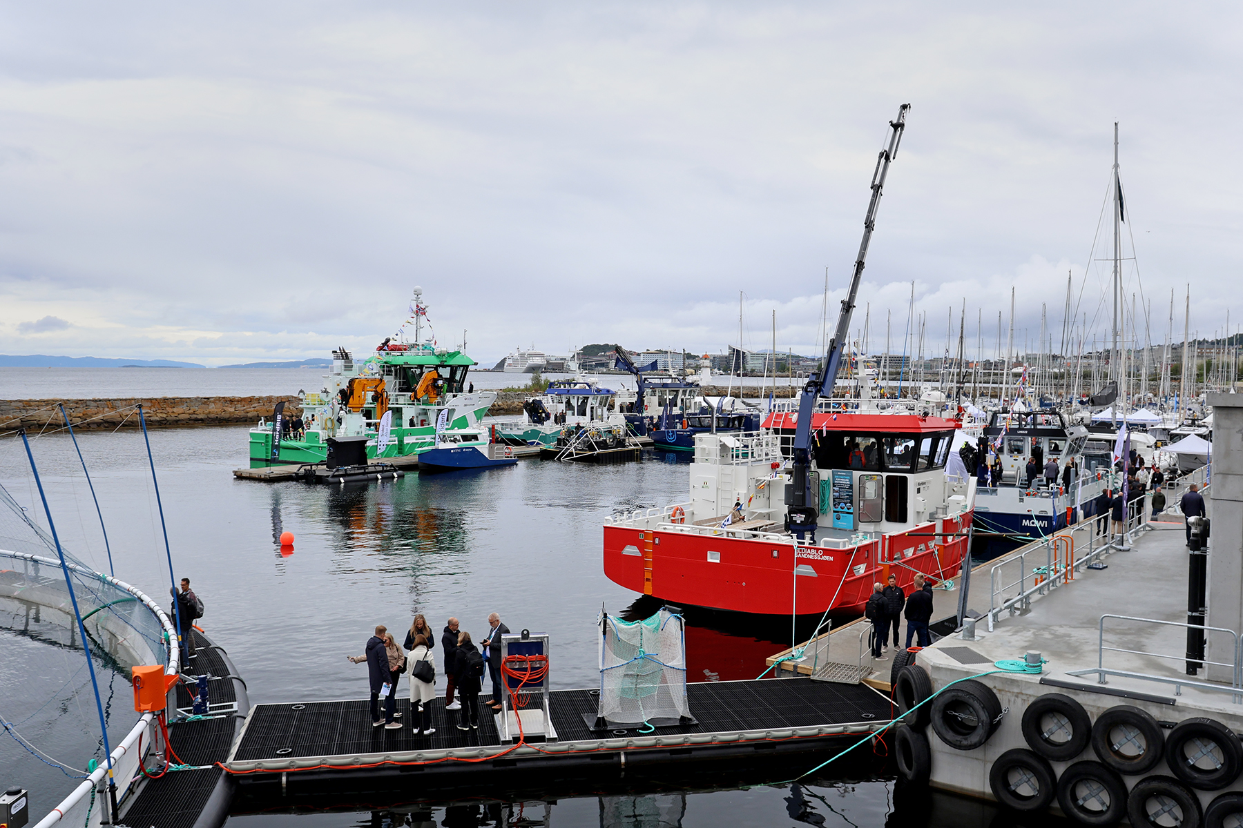 Store fôrflåter, ei oppdrettsmerd og arbeidsbåter i ulike størrelser på rad og rekke. Verdier for mange 100 millioner kroner vises fram på Skansen under Aqua Nor. Den røde båten er bygd i Flatanger.