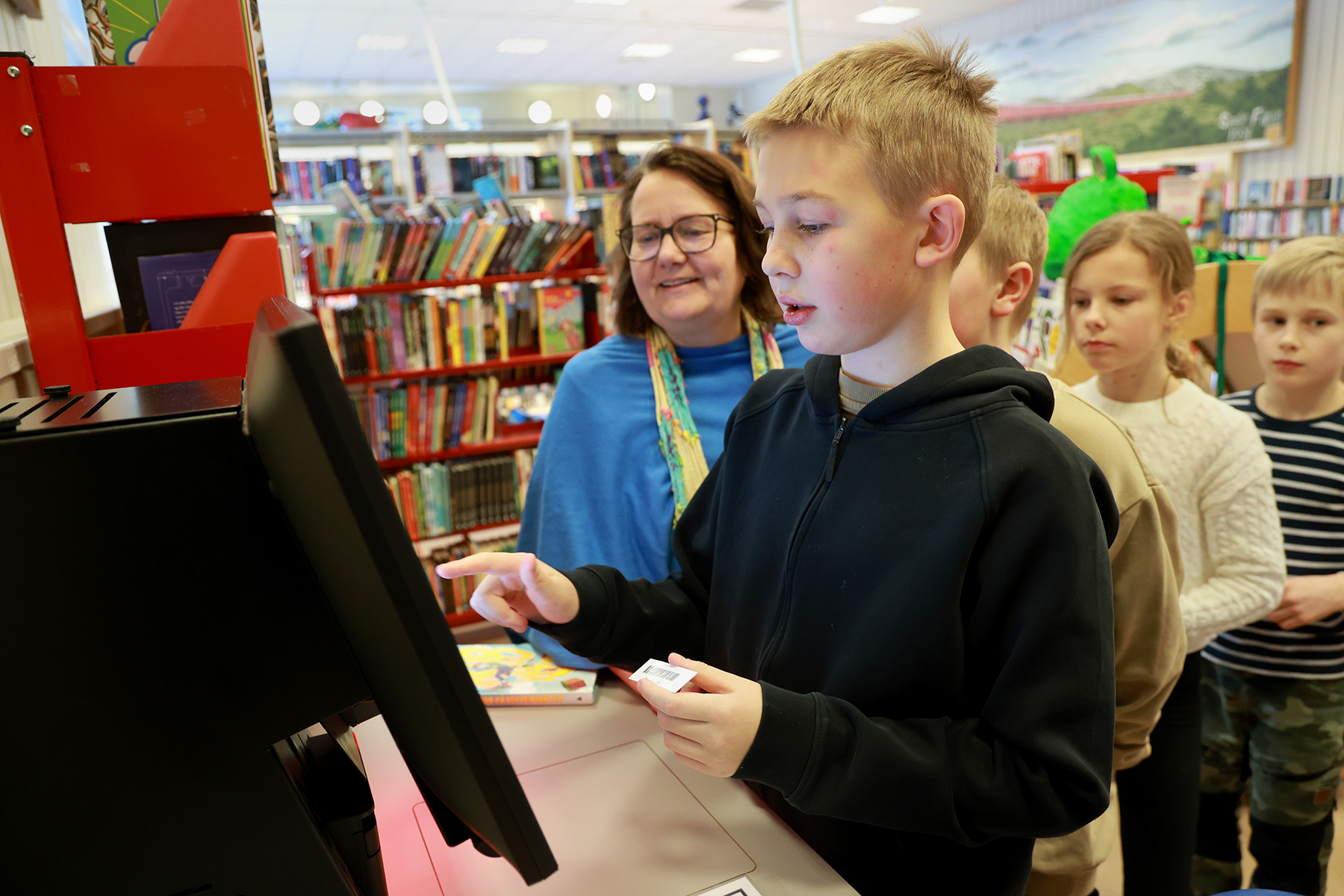 Philip ble den første til å prøve den nye utlånsautomaten. Bibliotekar Turid Kjendlie viste elevene hvordan de kunne registrere boklån, og alle elevene har fått hvert sitt lånekort.