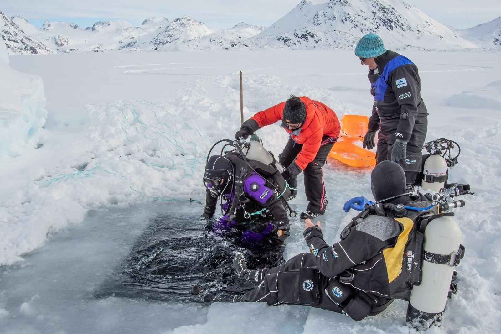 ARKTISK DUKKERT: Folk fra hele verden &oslash;nsker &aring; dykke med Northern Explorers. Her hjelper Anja Dietze noen av kundene. Foto: Privat.