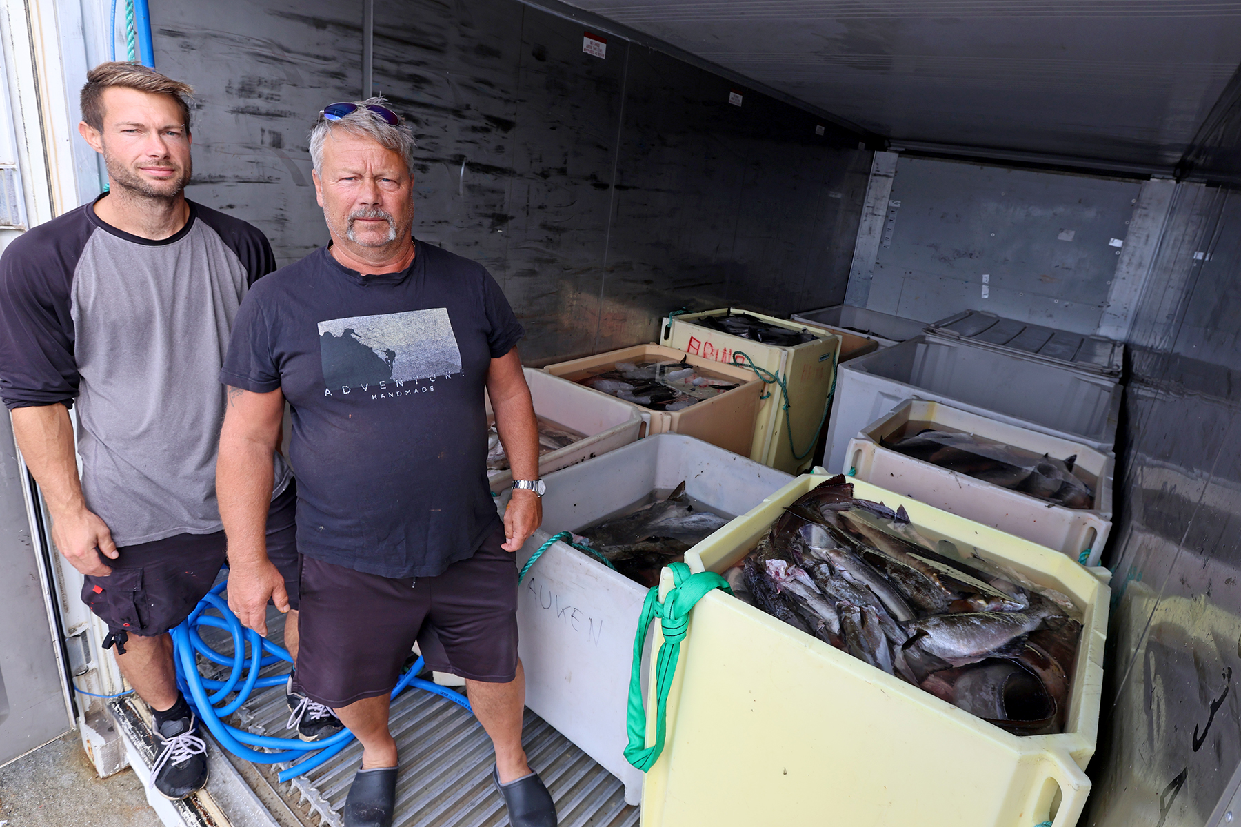 Patrick Bj&oslash;rsvik Dahle (til venstre) og Arve Bj&oslash;rsvik leverer fisk til den nye mottaksstasjonen p&aring; Kval&oslash;yseter.