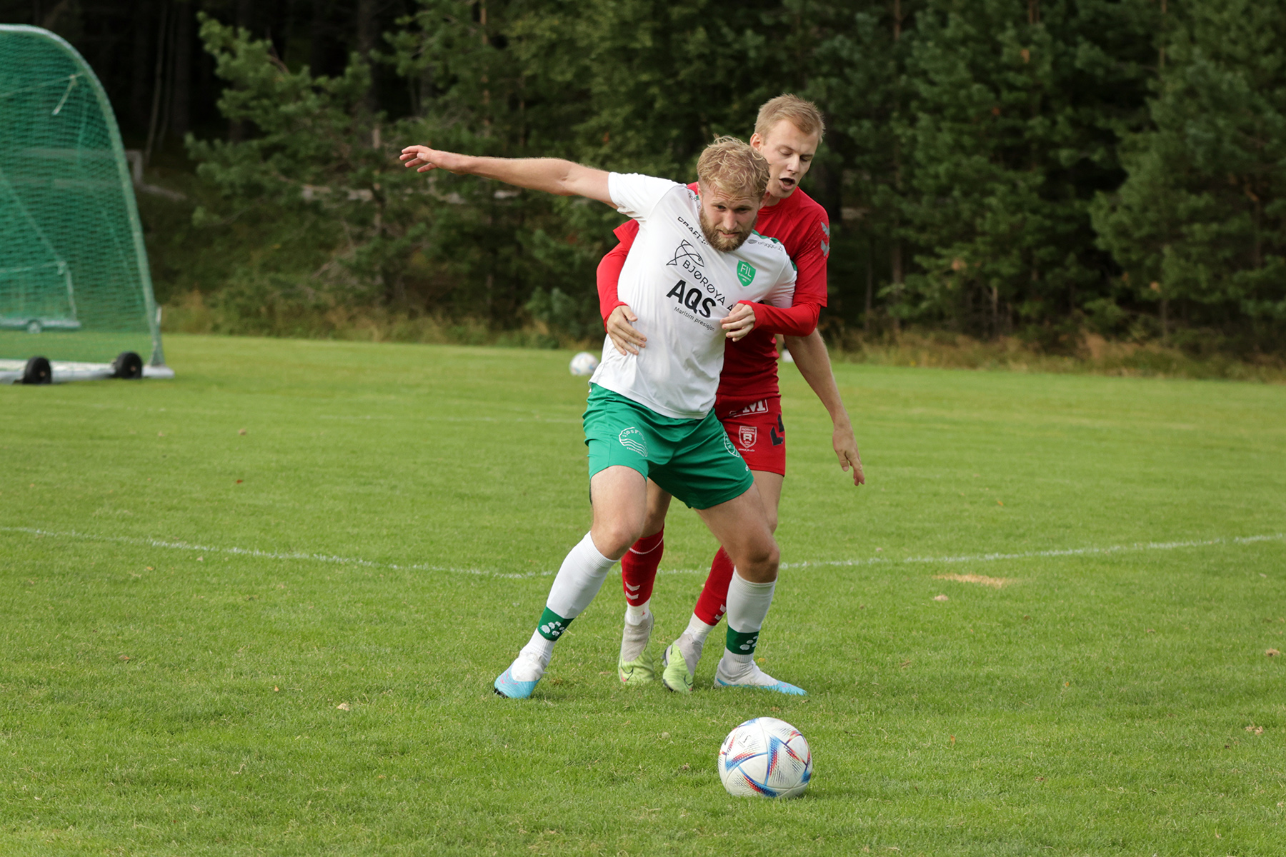 Ola Kristian Dahle H&oslash;stland blir omfavnet, alternativt holdt, av en R&oslash;rvik-spiller.