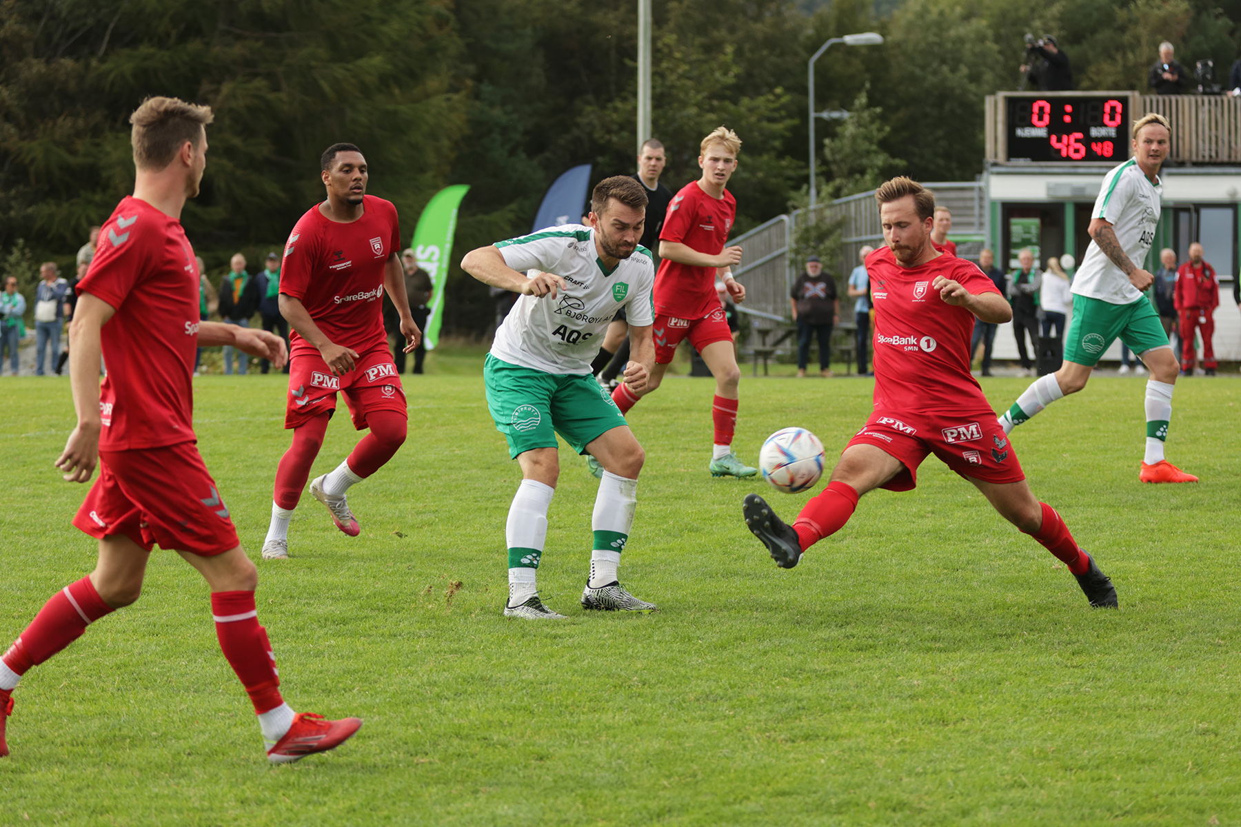 Flatangers Thomas Einvik i duell med R&oslash;rvik-spillere.