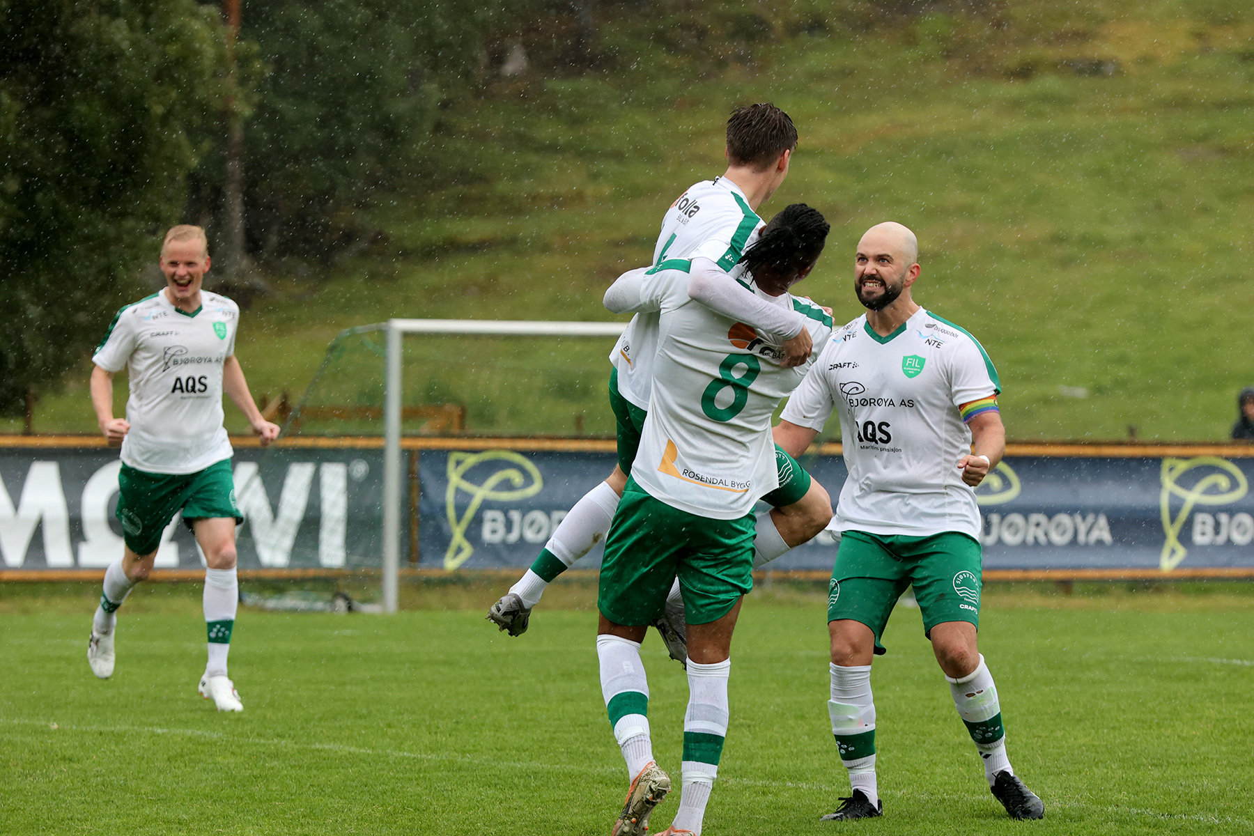 Debutanten Jesper Andreassen blir gratulert av medspillerne. Kaptein Øystein Sexe Olsen til høyre.