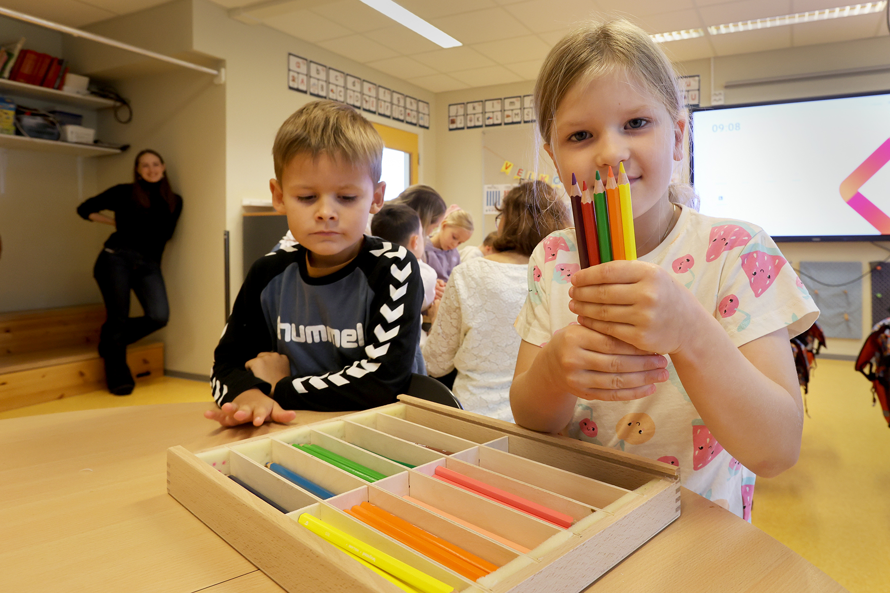 Fr&oslash;ya finner de rette fargeblyantene for &aring; fargelegge hunden. Til venstre Leon, som lurer p&aring; hvilke farger han skal bruke..
