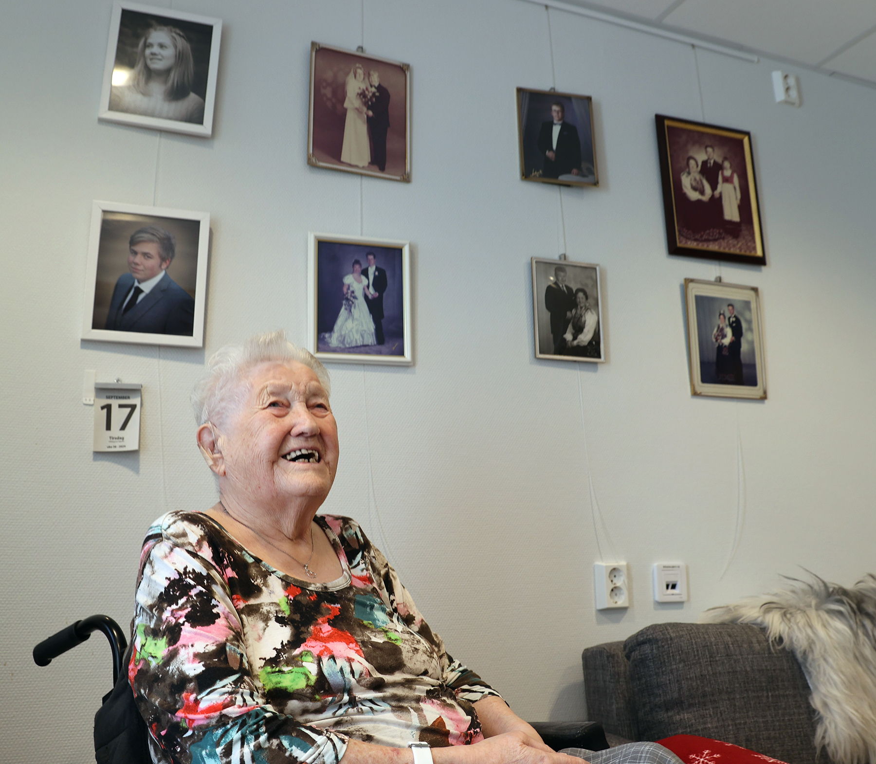 Judith foran familieveggen, der bryllupsbildet av Kjell Magne og Ragnfrid henger i midten.