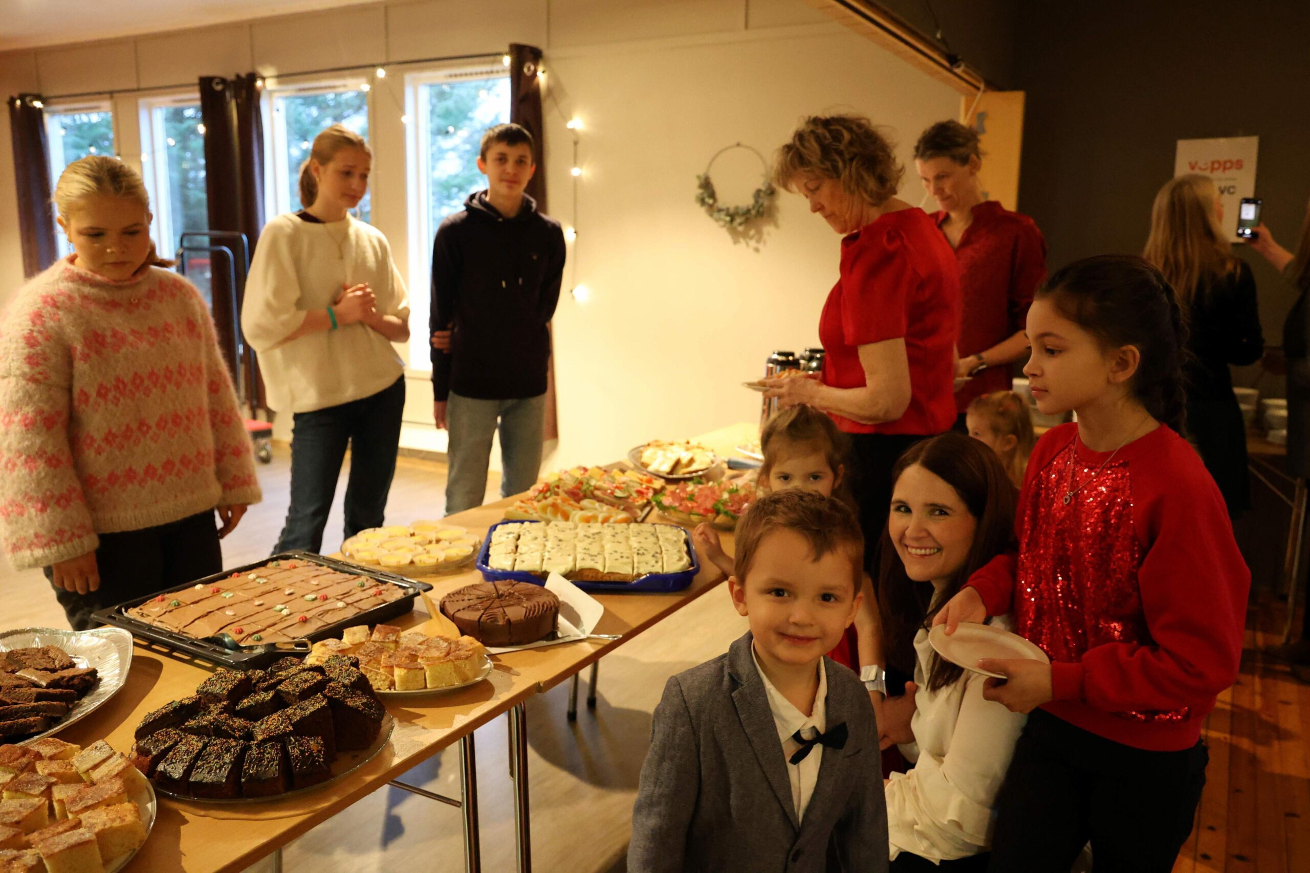 Erica, Leyna og Kasper serverer til barn og voksne. Margit Ekker D&oslash;lvik og barna Elias (foran), Agnes (bak) og Lotta (til h&oslash;yre) vil pr&oslash;ve kakene.