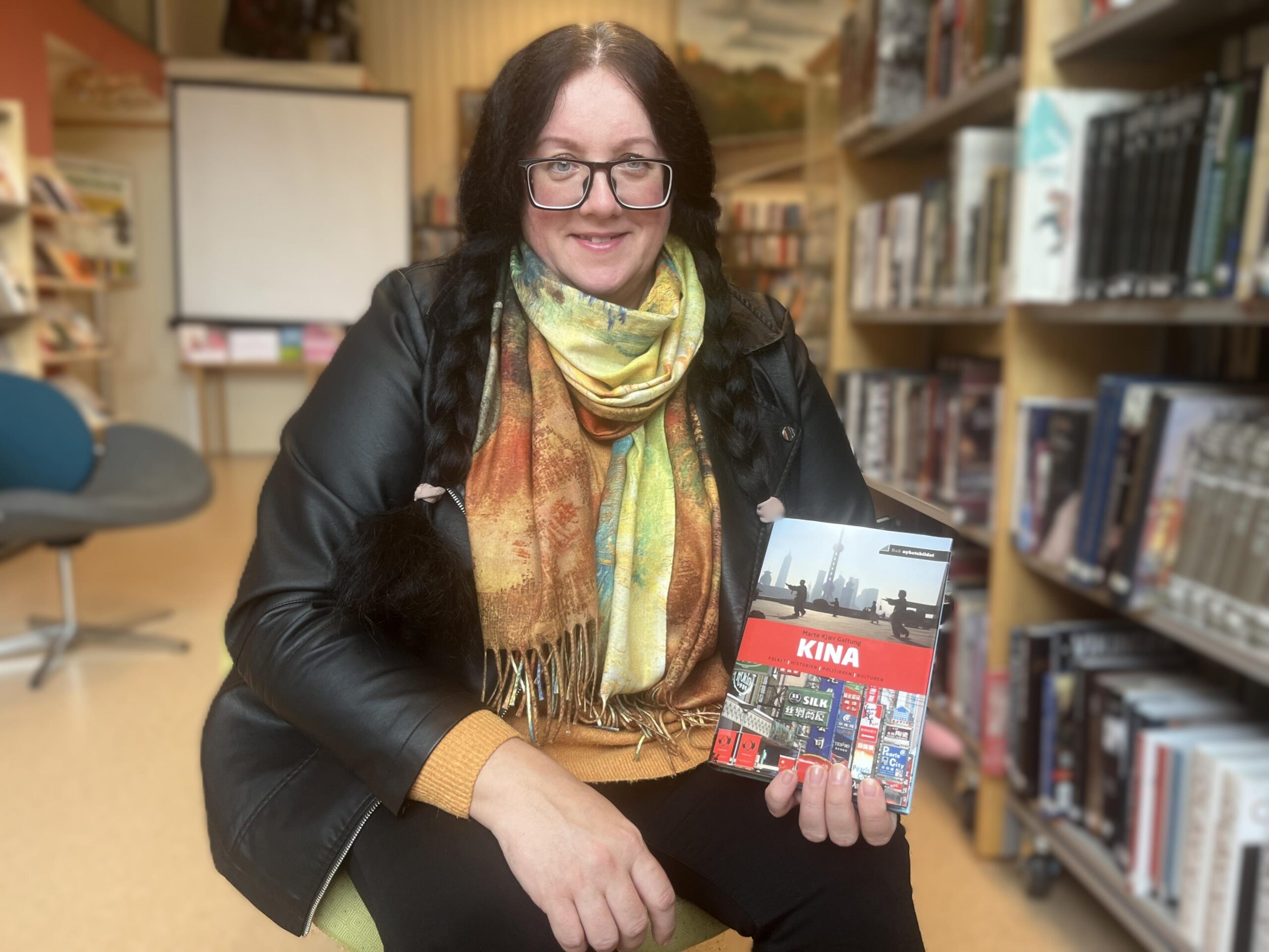 Kristina elsker &aring; reise - og &aring; lese. Her med en bok om Kina, hennes siste turm&aring;l. 