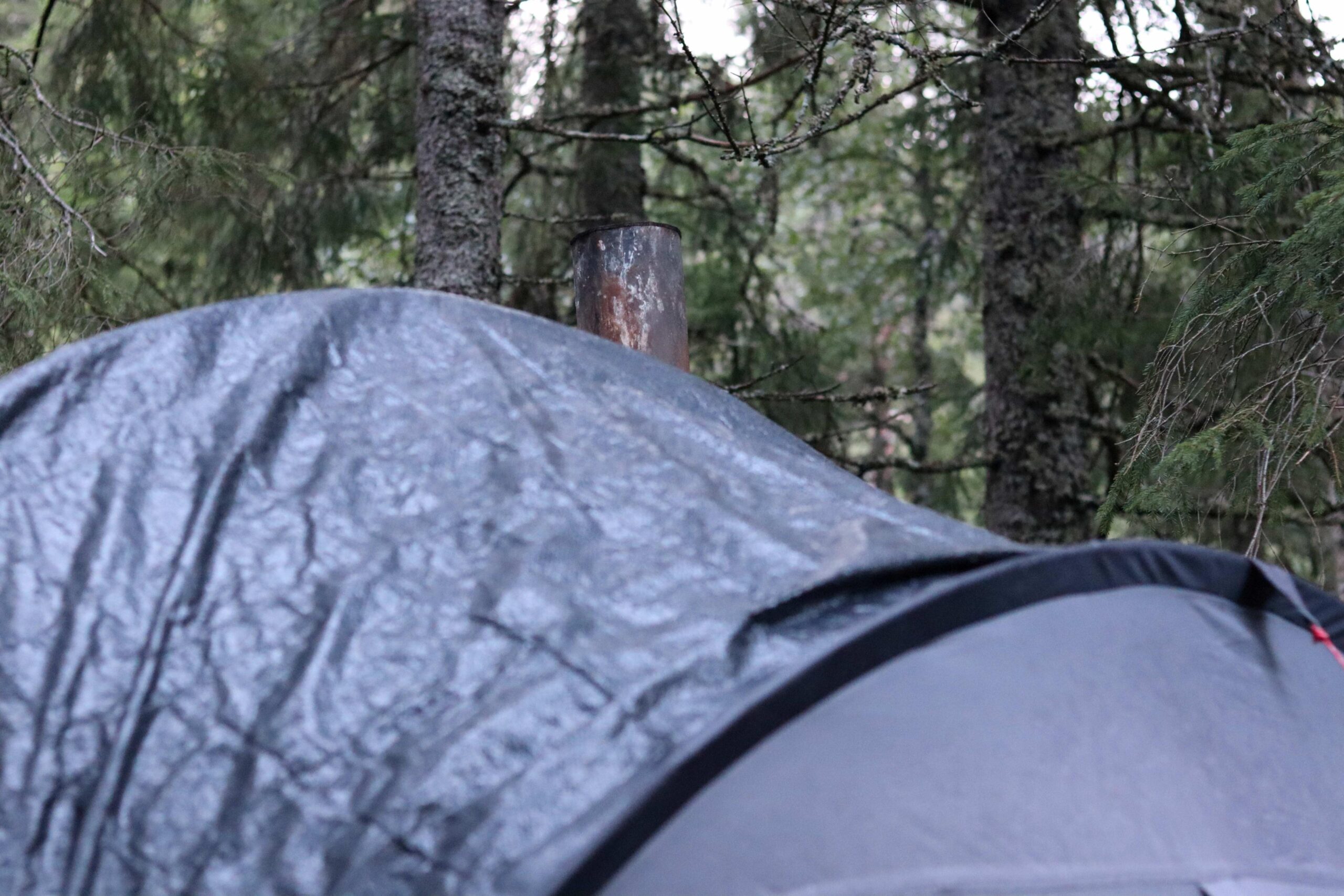 Paret holder varmen i teltet med vedovn. 