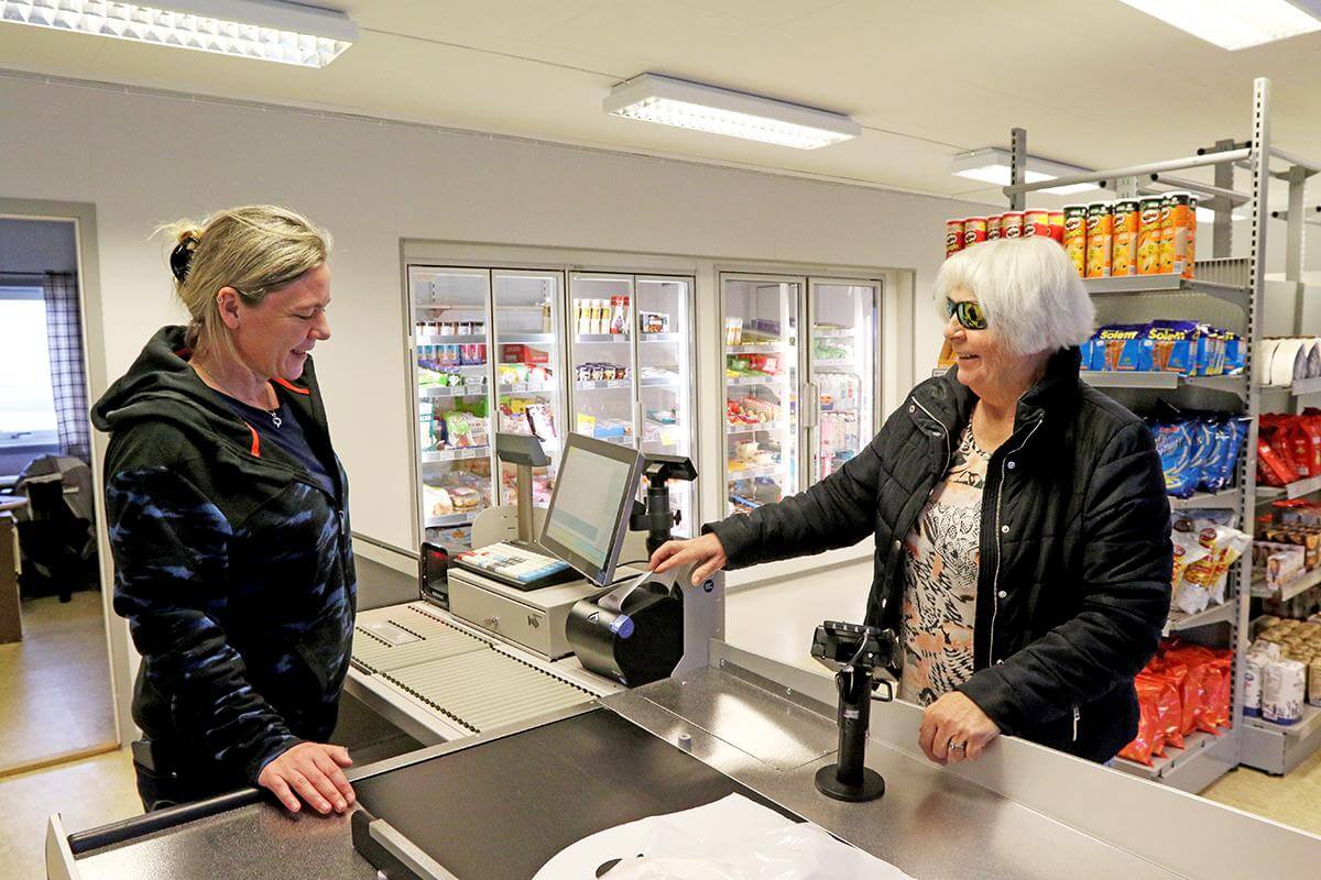 Flere tar sin tørn i kassa. Mona Skinstad jobber dugnad, og tar imot betaling fra Unni Juul Tørriseng.