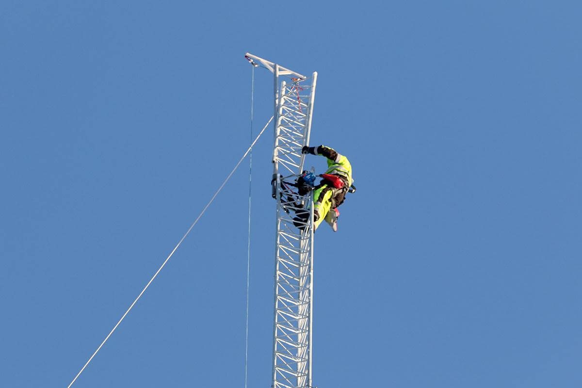 Øverst i masta, 60-70 meter over bakken, henger en montør som setter sammen elementene.