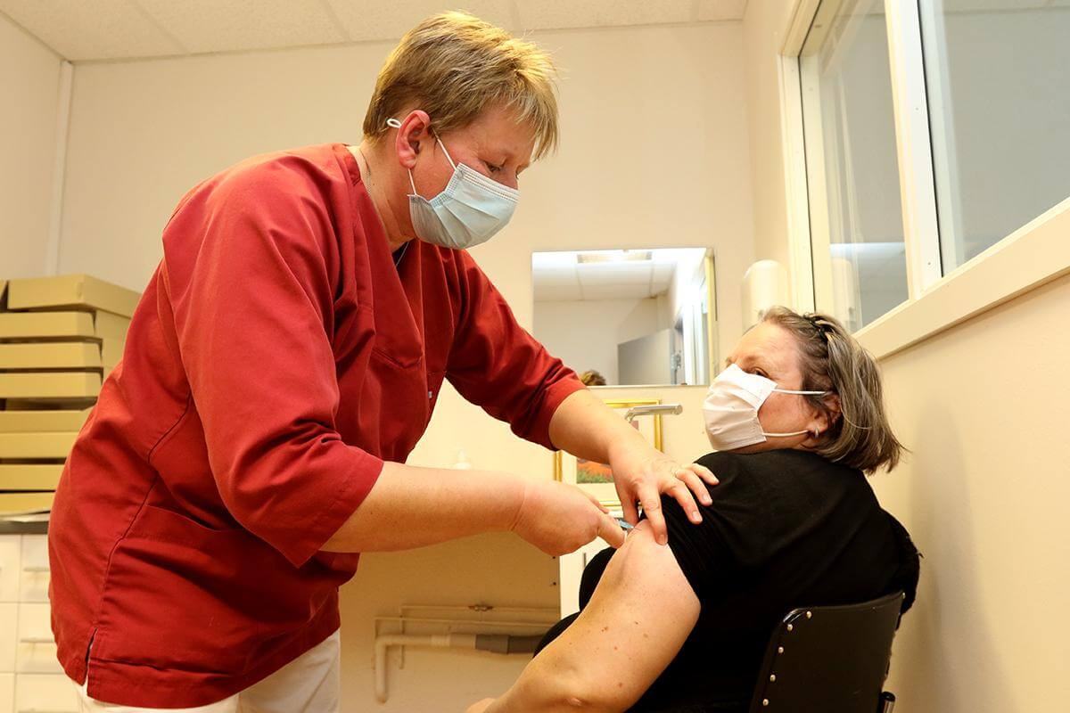 Grethe Bang setter vaksinedose på Kari Imsgard, som ble tilkalt på kort varsel for å få vaksine da en person ikke møtte som avtalt.