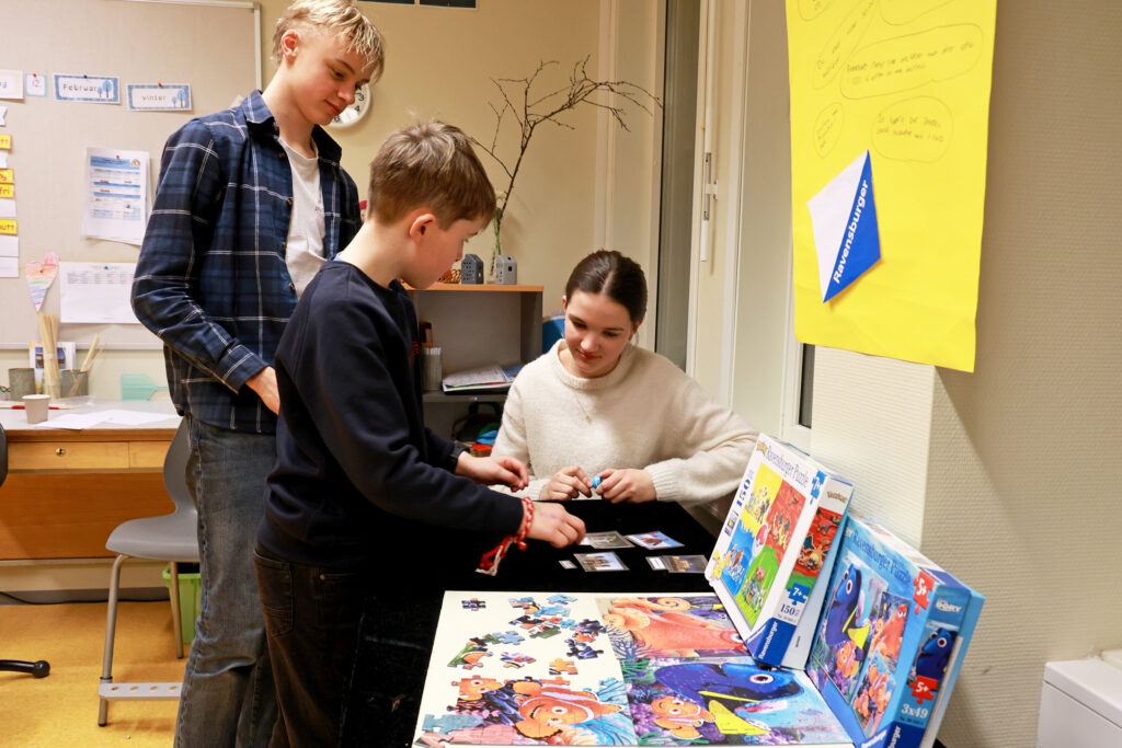 Sverre prøver seg på puslespillet på utstillinga om Tyskland, som Albert og Lovise har vært med på å lage.