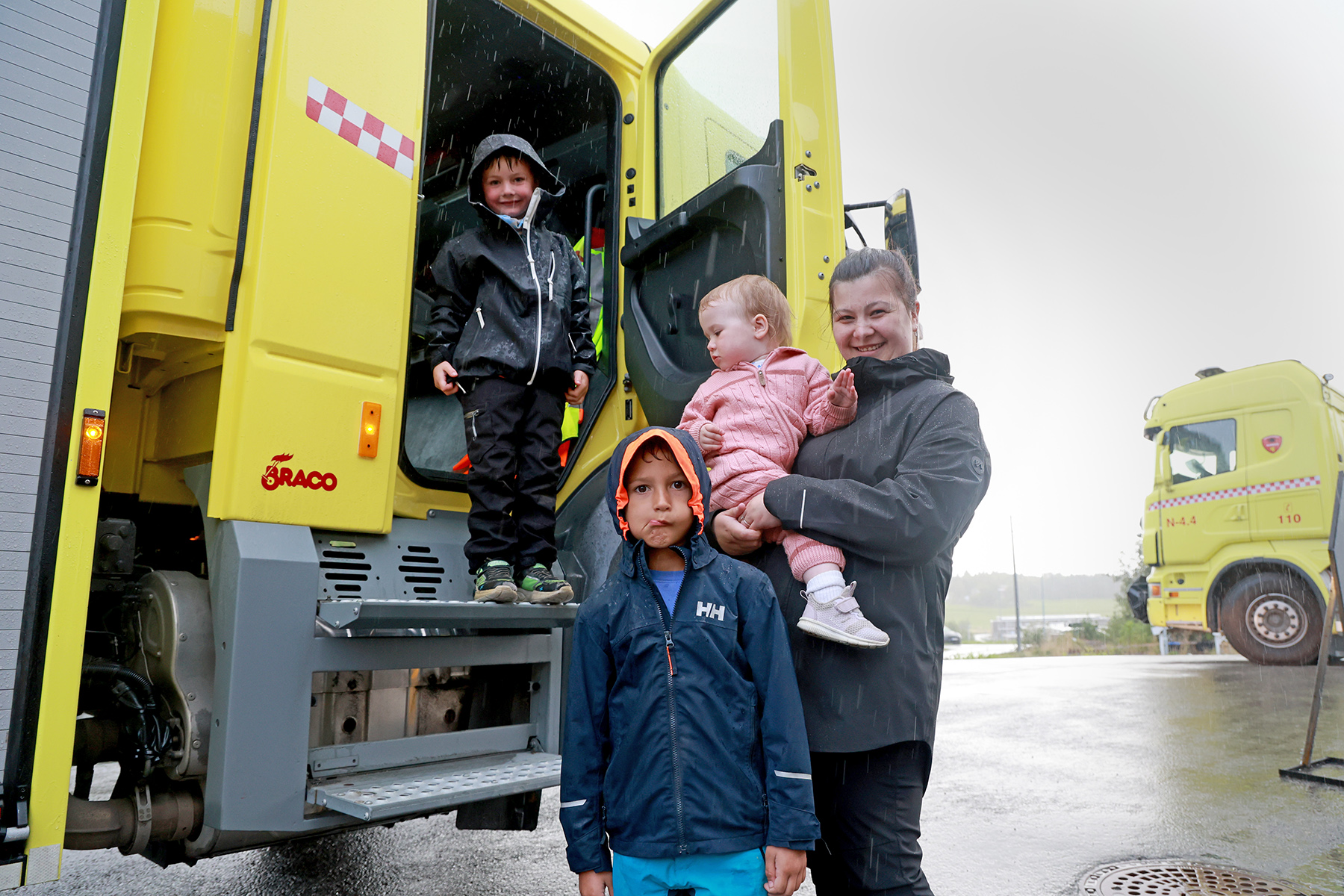 Brannbilen gikk i skytteltrafikk med unger som ville sitte på. Her er det Leon, Jan Otto og Lene Nilsen med Tiril som skal ut på tur.