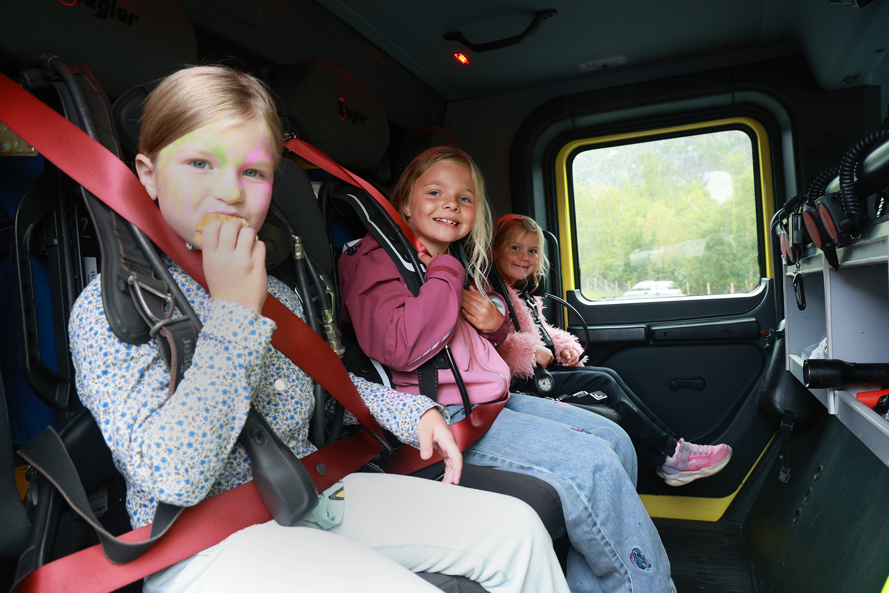 Frøya (til venstre), Ulrika og Sofie klar for kjøretur med brannbilen.